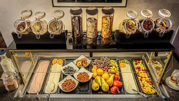 Ein reichhaltiges Buffet mit verschiedenen Speisen, darunter Obst, Gemüse und unterschiedliche Aufstriche.