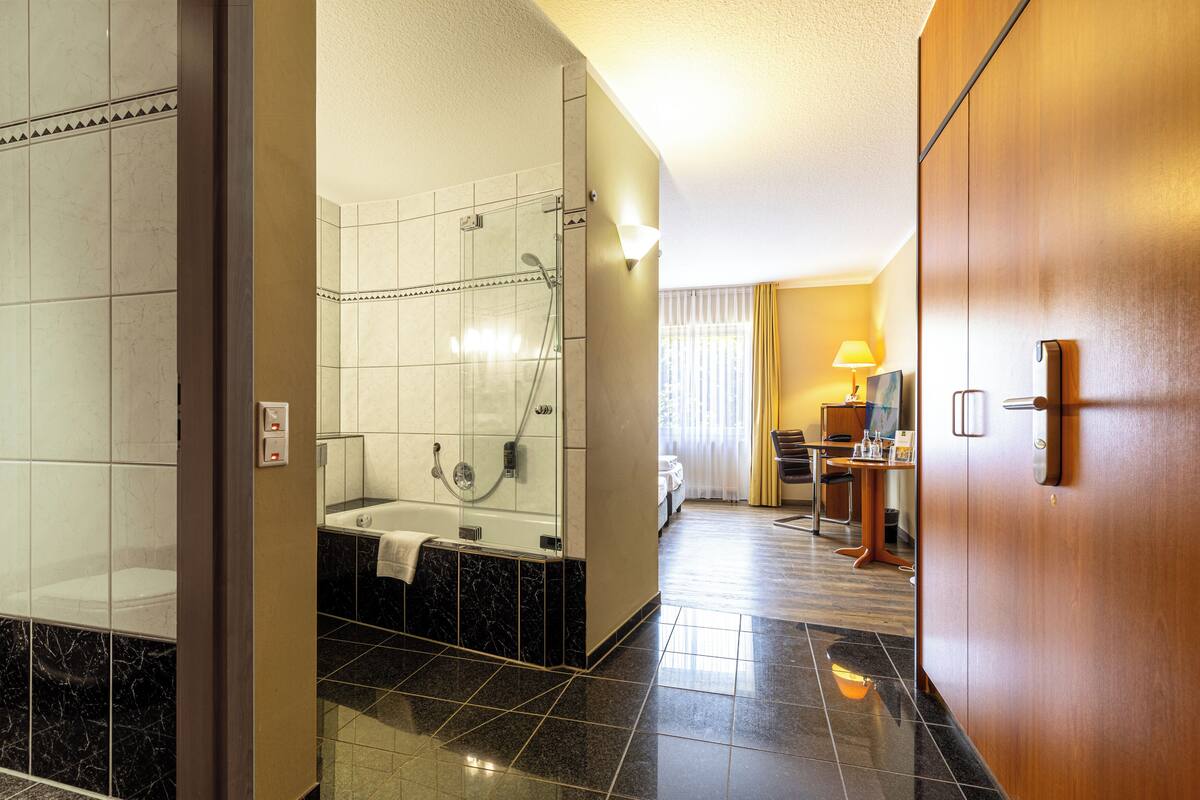 A hotel bathroom with a shower, bathtub, and toilet.