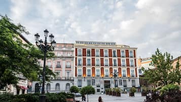A historic building with a central courtyard, featuring a statue, benches, and a fountain.