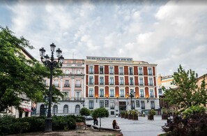Il s’agit d’un bâtiment historique doté d’une cour intérieure, où l’on trouve une statue, des bancs et une fontaine.