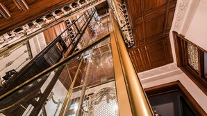 Una gran escalera con barandillas ornamentales y acabado de madera pulida.