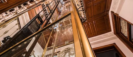 Una gran escalera con barandillas ornamentales y acabado de madera pulida.