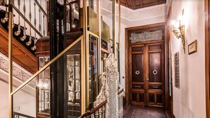 Una imponente escalera con barandillas ornamentadas y un acabado de madera pulida.