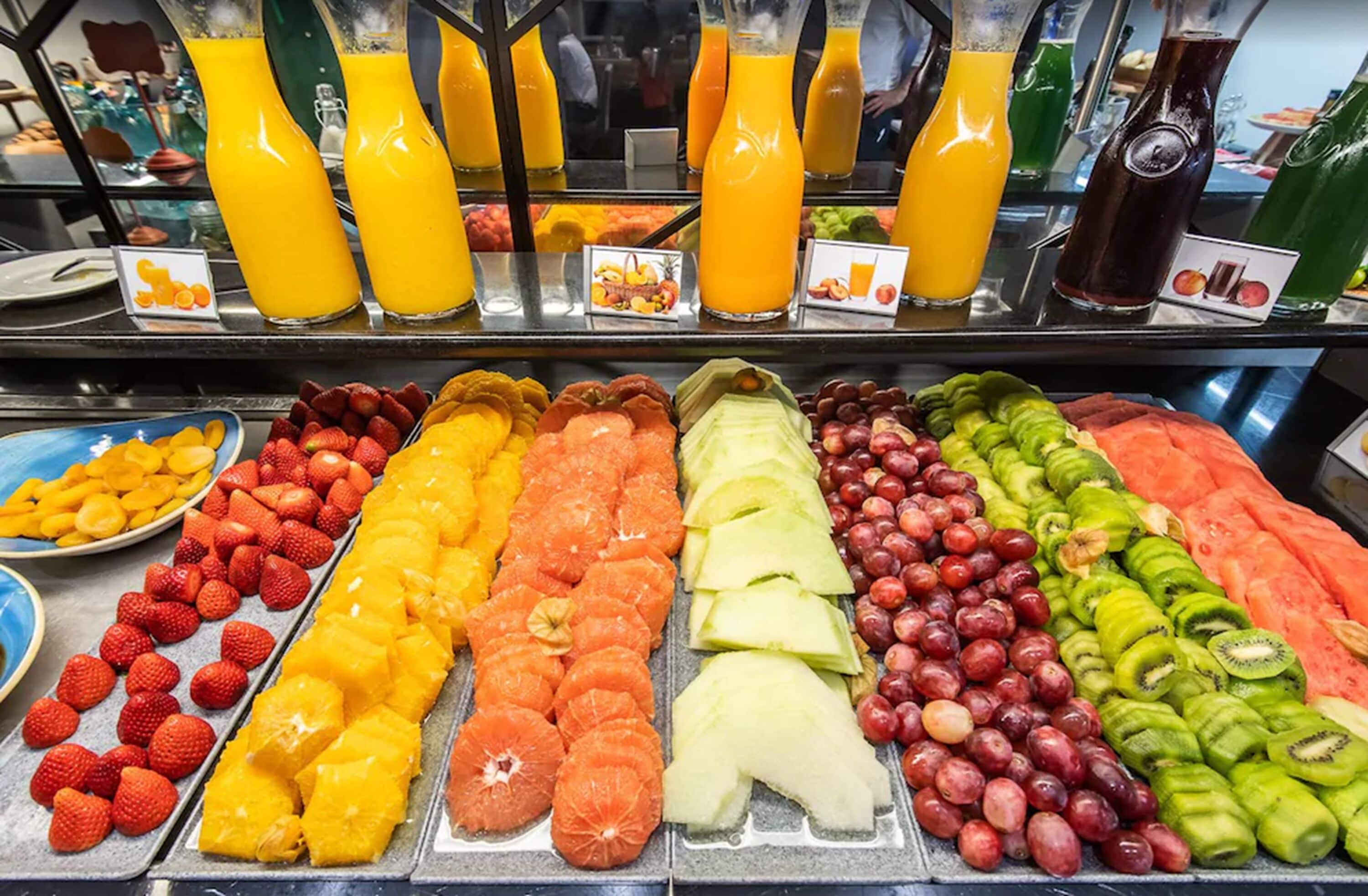 A breakfast buffet with various fruits and juices.