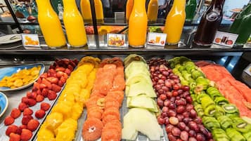 A breakfast buffet with various fruits and juices.
