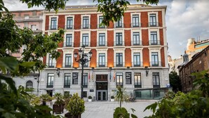 Un edificio de varios pisos con fachada simétrica, ventanas amplias y una entrada central.