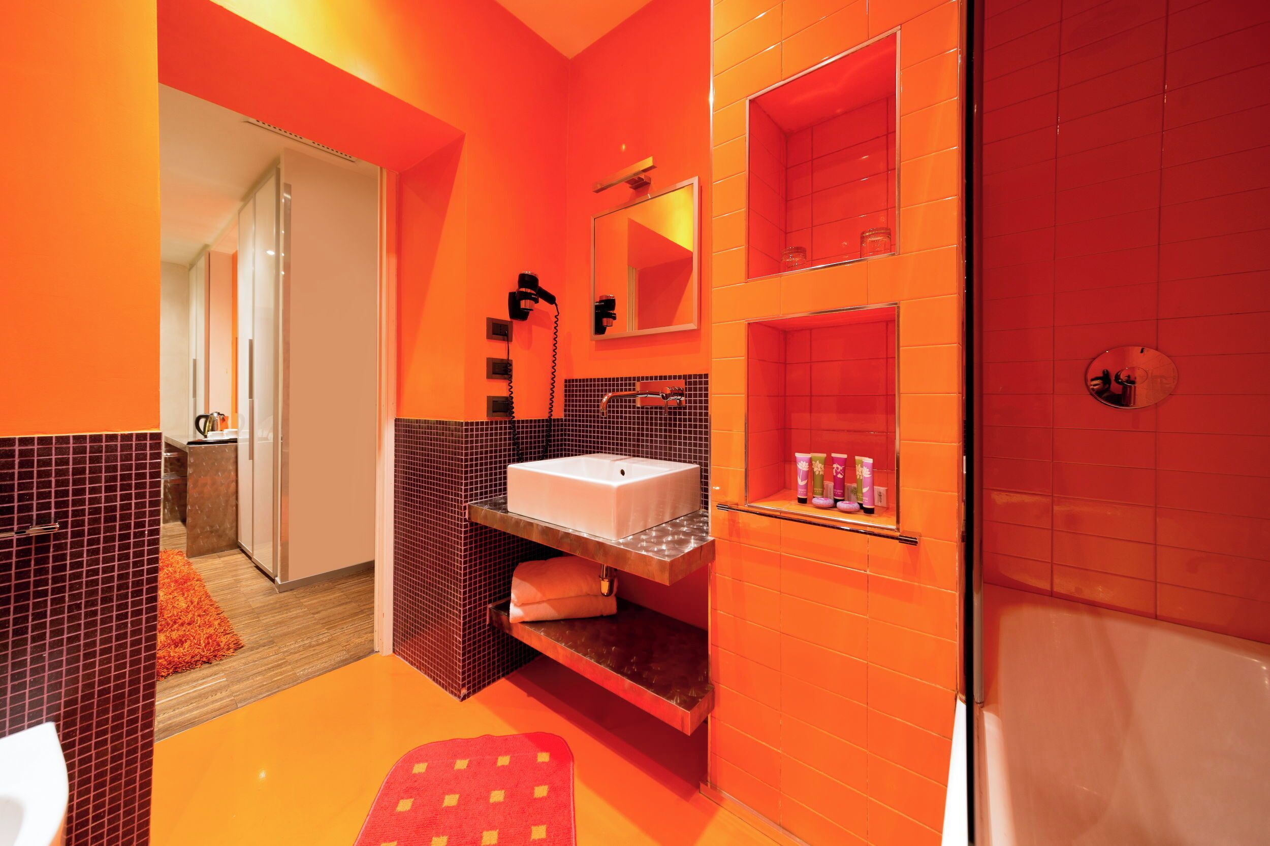 Une salle de bain moderne avec un grand miroir, un lavabo et un espace douche.