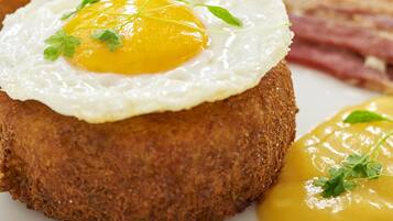 A breakfast plate with a fried egg, toast, and bacon.
