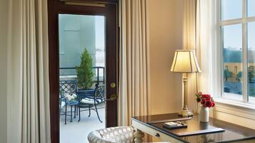 Une chambre d’hôtel équipée d’un bureau, d’une chaise, d’une lampe et offrant une vue sur le balcon extérieur.