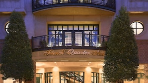 Entrada de hotel con un balcón y una escalera.