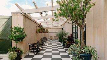 A checkered outdoor patio with seating and potted plants.