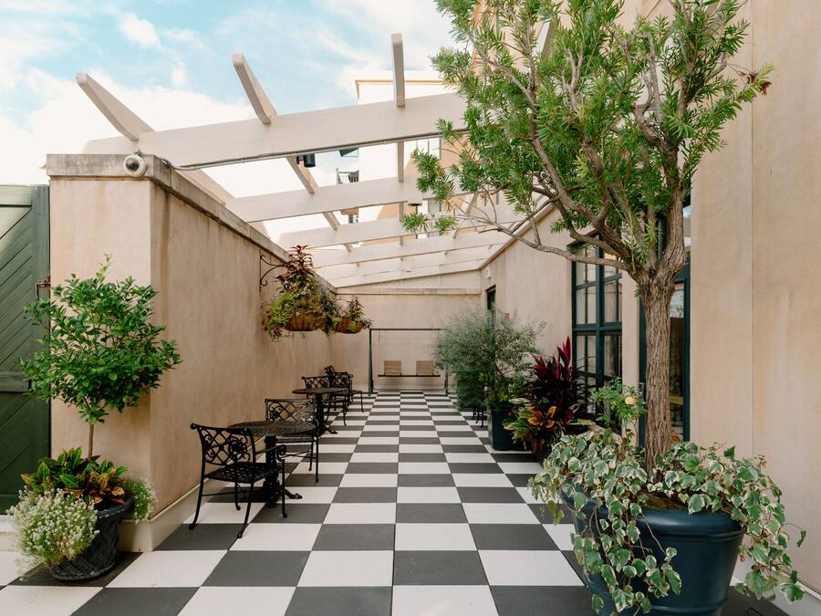 A checkered outdoor patio with seating and potted plants.