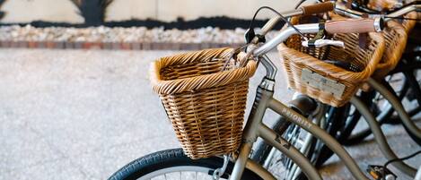 Un vélo doté d’un panier en osier et d’un cadre en métal, garé devant un mur sur lequel on peut lire : « FRENCH QUARTER Inn ».