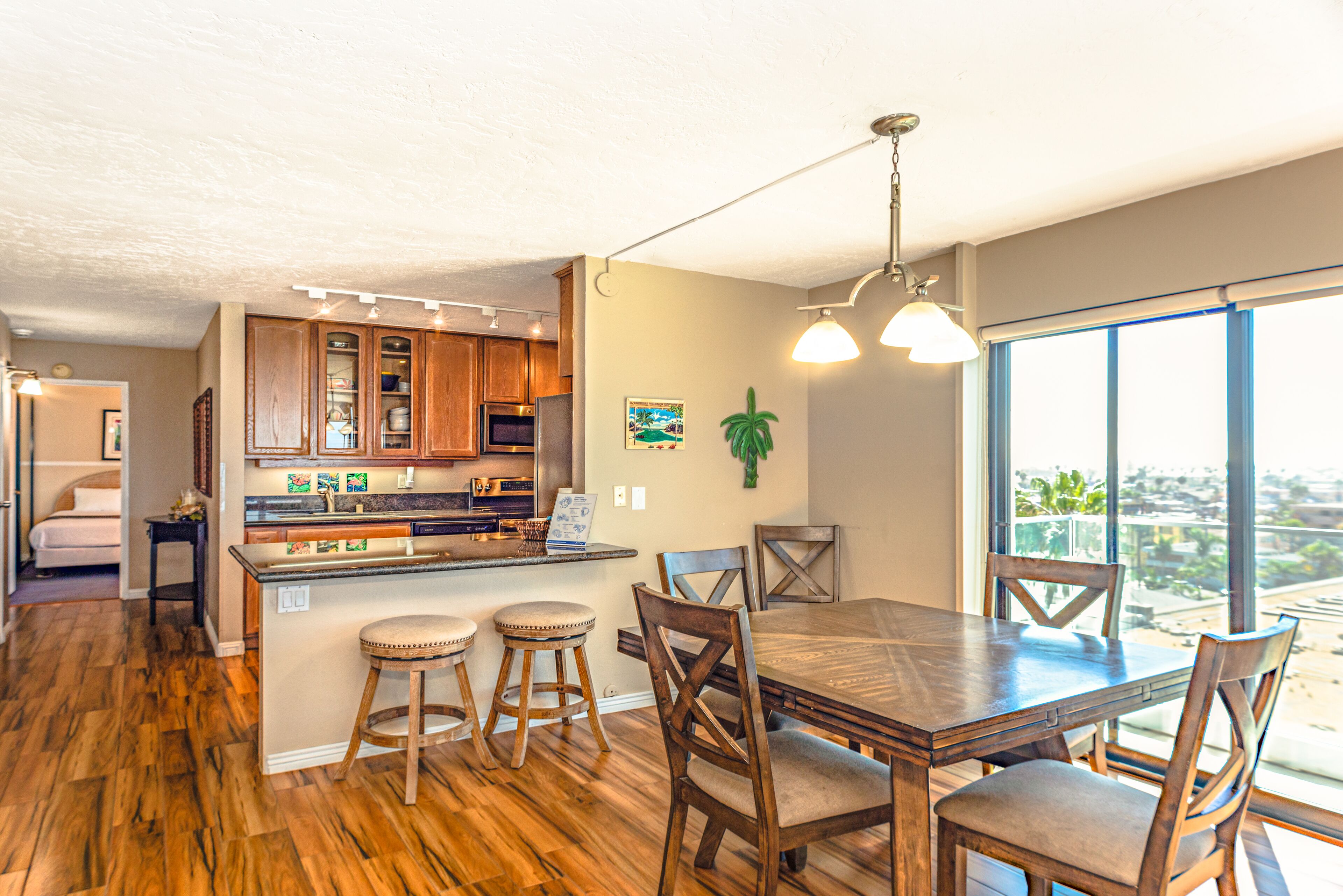 A modern kitchen with wooden cabinets, a central island, and bar stools.