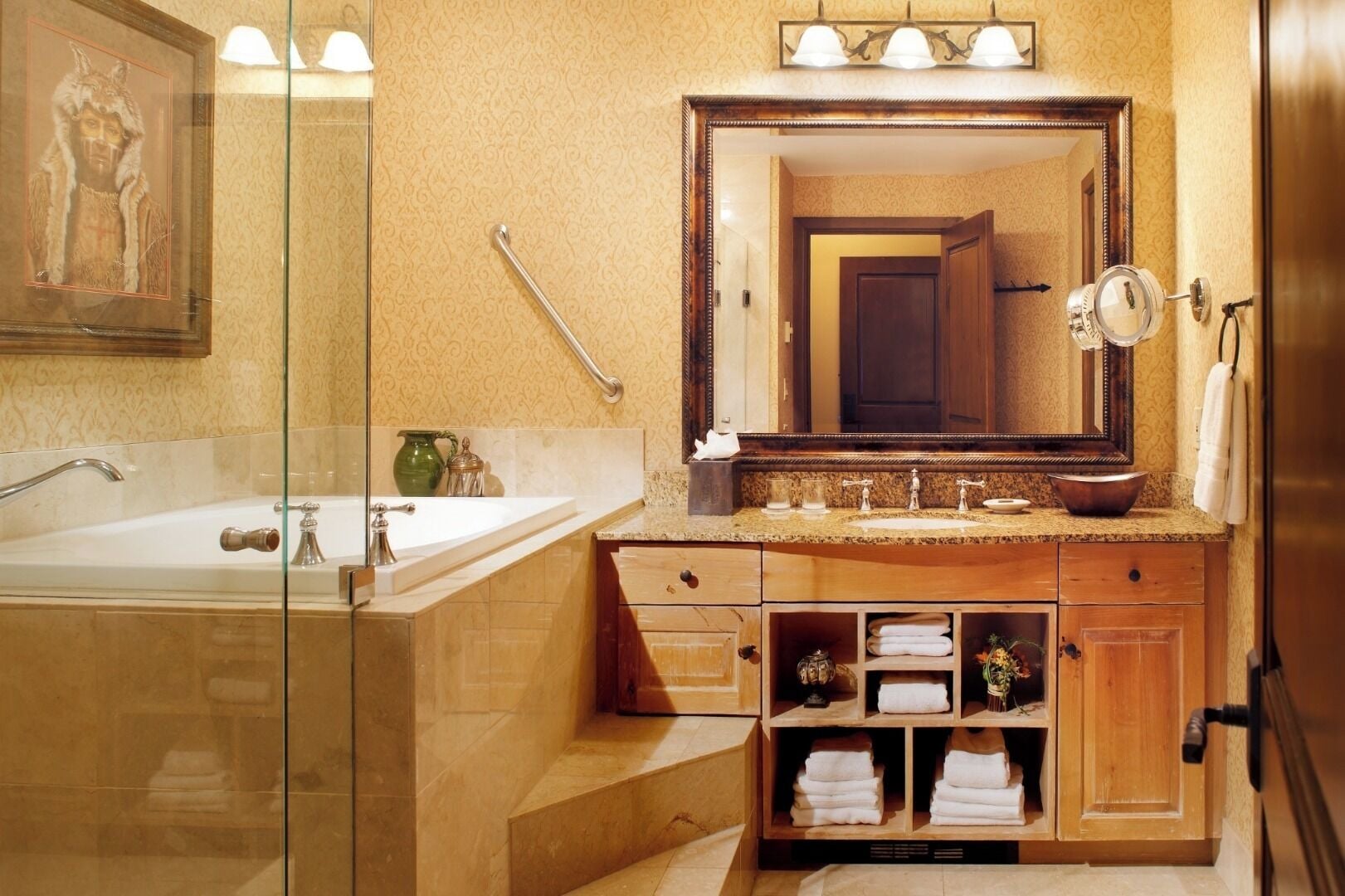 A bathroom with a large mirror, a bathtub, a vanity with a sink, and a towel rack.