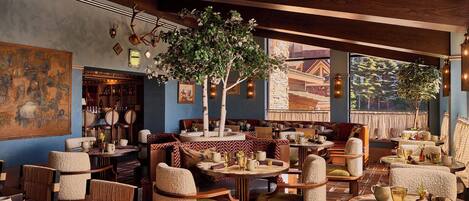 Un restaurante acogedor con muebles de madera, un cuadro grande y vistas a un edificio.