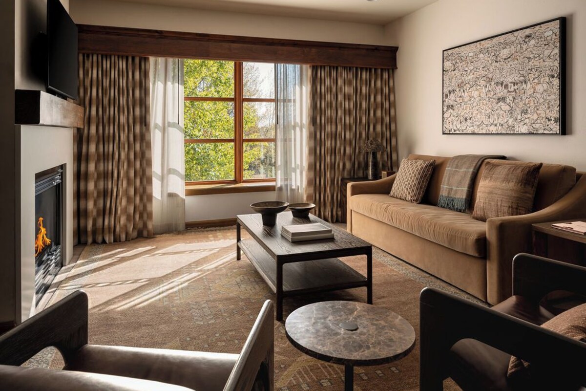 A living room with a fireplace, a sofa, a coffee table, and a television.