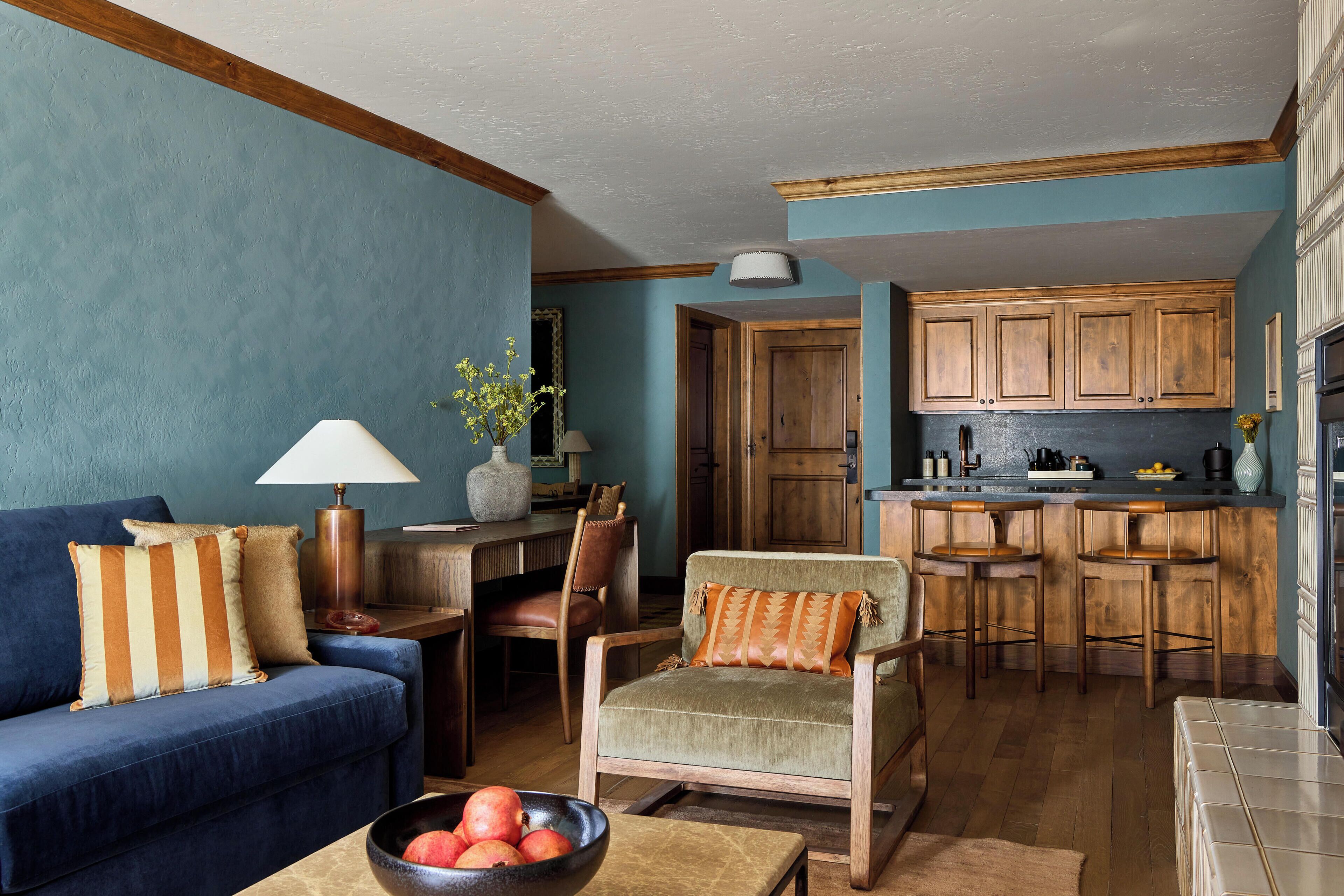 Een woonkamer met een bank, fauteuil, en een eethoek met een tafel en stoelen.