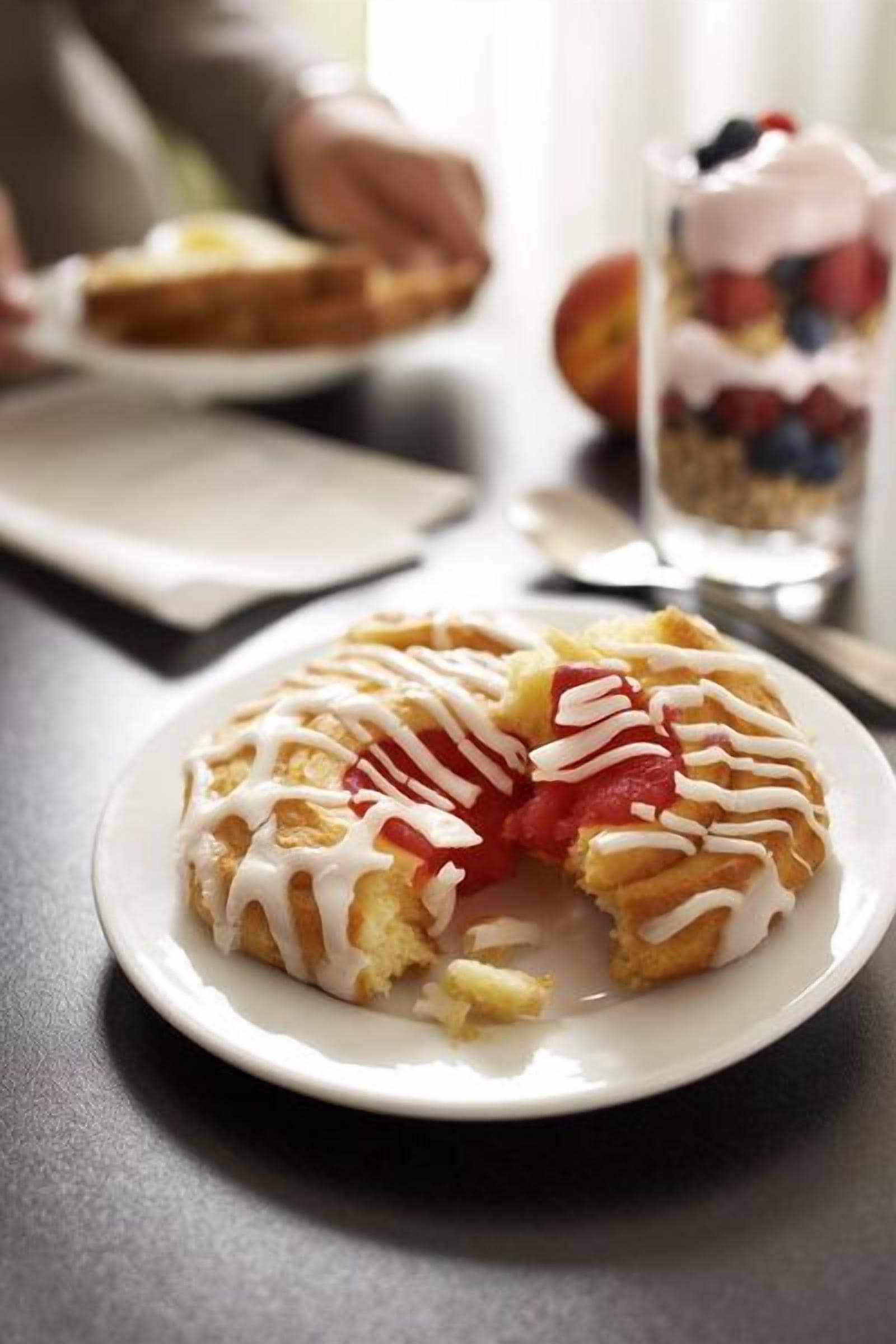 En dessert på en tallerken med hvid glasur og frugtstykker.