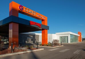 A modern hotel with a prominent sign for 'Coast Nisku Inn' and 'Montanas' branding.