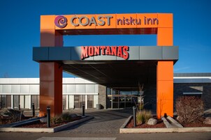 Entrada de un hotel con un letrero destacado que dice 'COAST nisku inn' y 'MONTANAS'.