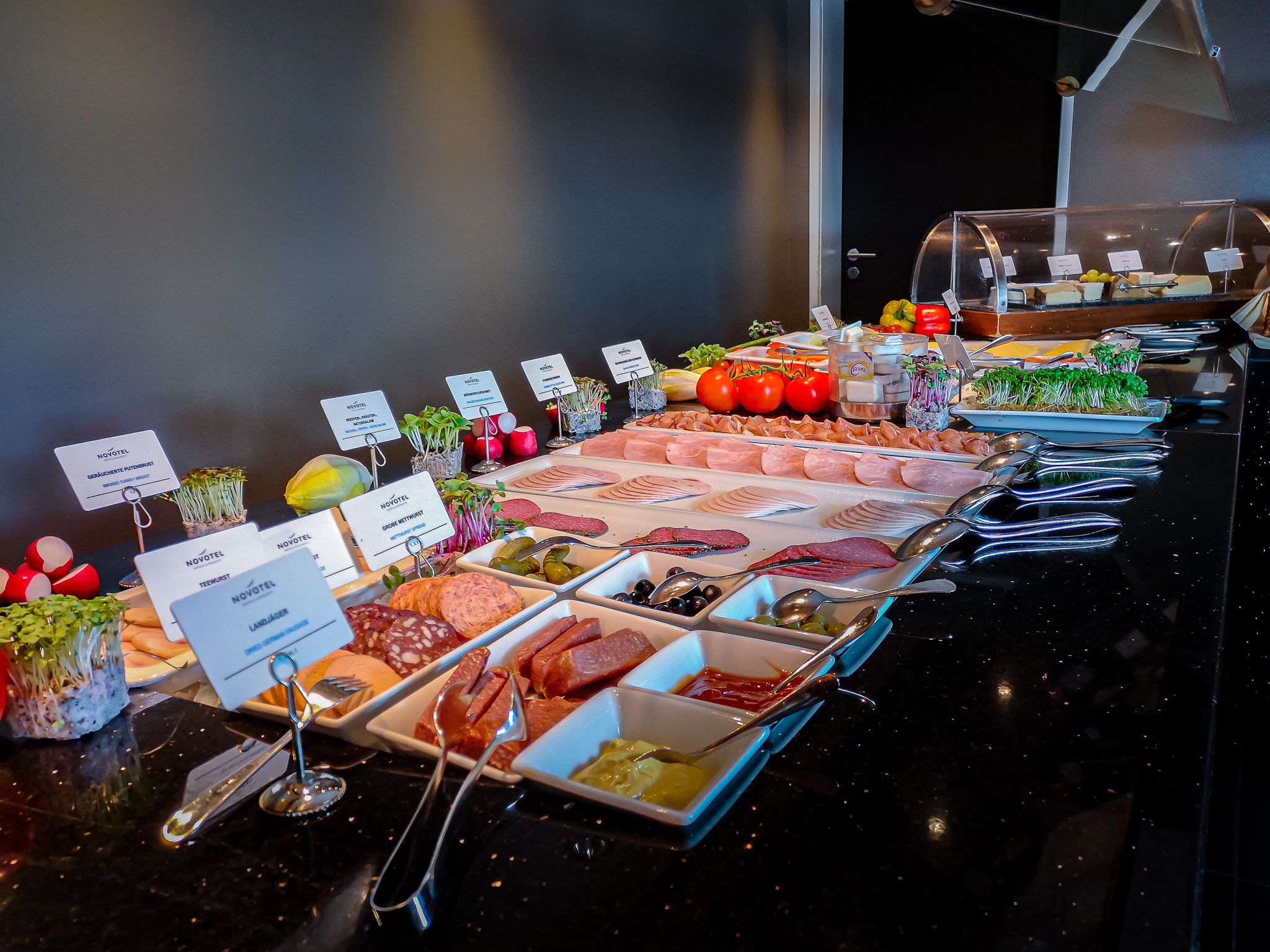 A buffet with various food items and labels.