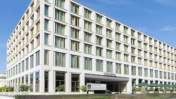 Un hotel moderno con fachada blanca, múltiples ventanas y un cartel que dice 'NOVOTEL'.