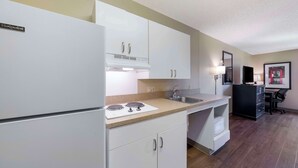 Una cocina moderna con armarios blancos, estufa integrada y un lavamanos.