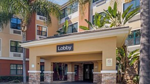 Un edificio con un letrero que dice 'Lobby', pilares de ladrillo y un cartel de 'No Fumar'.