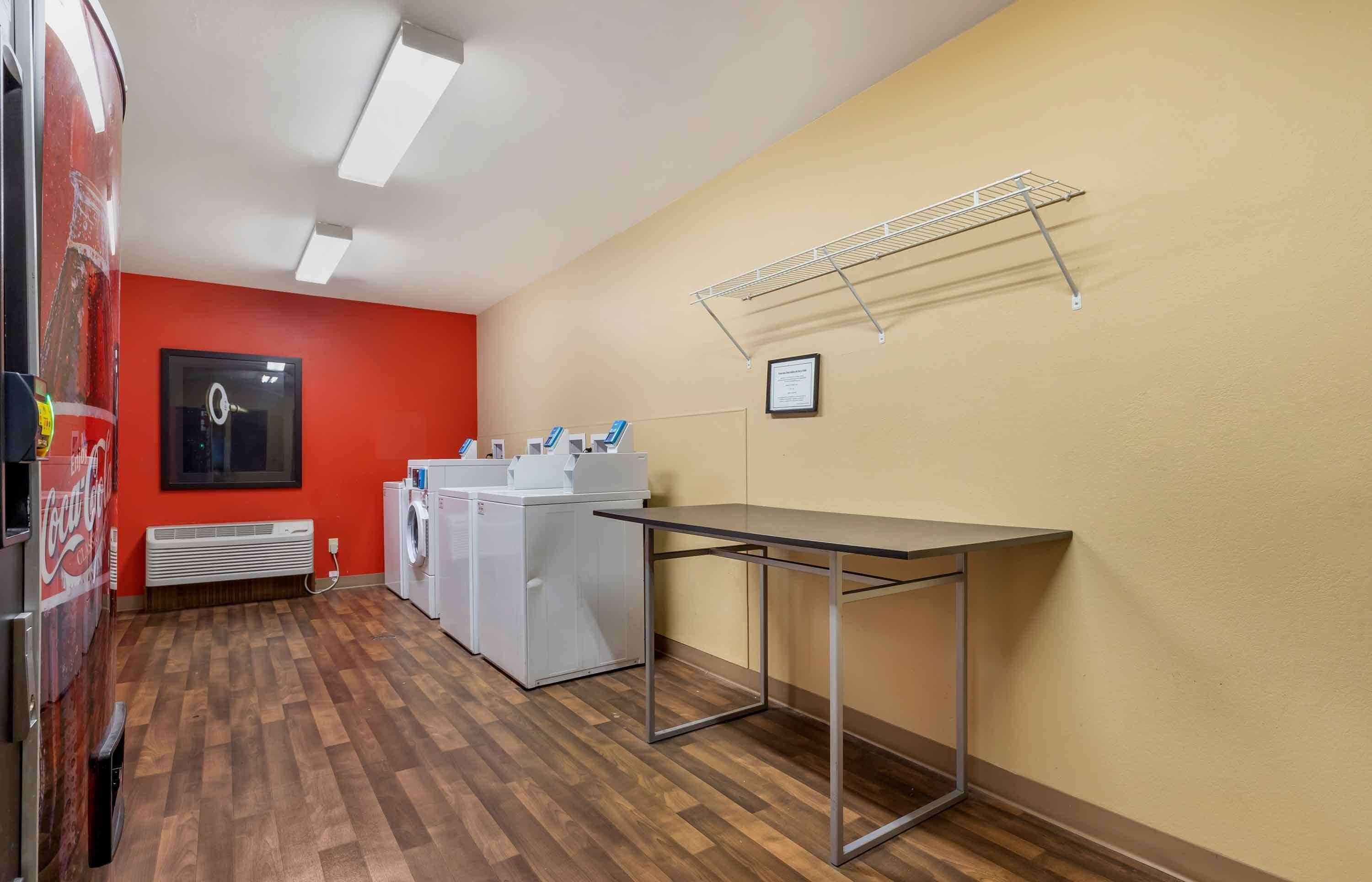 Une buanderie équipée d’un lave-linge, d’un sèche-linge et d’une table.