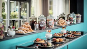 A buffet table with various food items and jars labeled 'CANDY SHOP'.