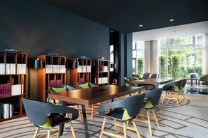 A modern library with bookshelves, a wooden table, and chairs.