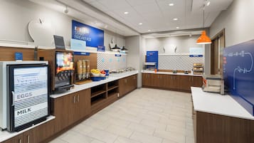 Un moderno comedor con un menú digital, una cafetera y diversas opciones de alimentos.