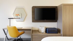 A hotel room with a desk, a yellow chair, a television, a bed, and a wardrobe. - Holiday Inn Express And Suites Seattle Downtown - Lake Union by IHG (Seattle)