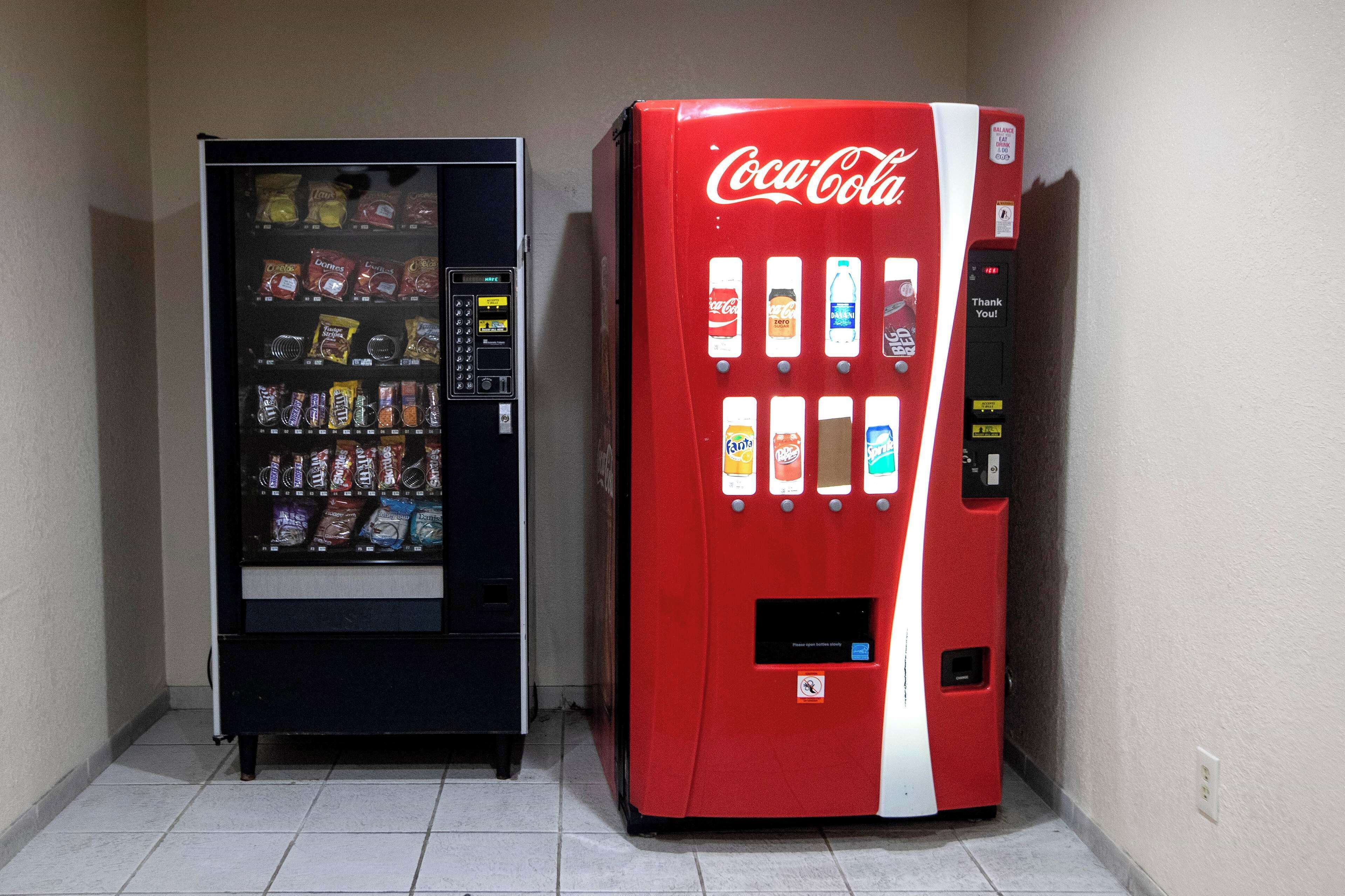 To salgsautomater, en med Coca-Cola logo og den anden med forskellige snacks.