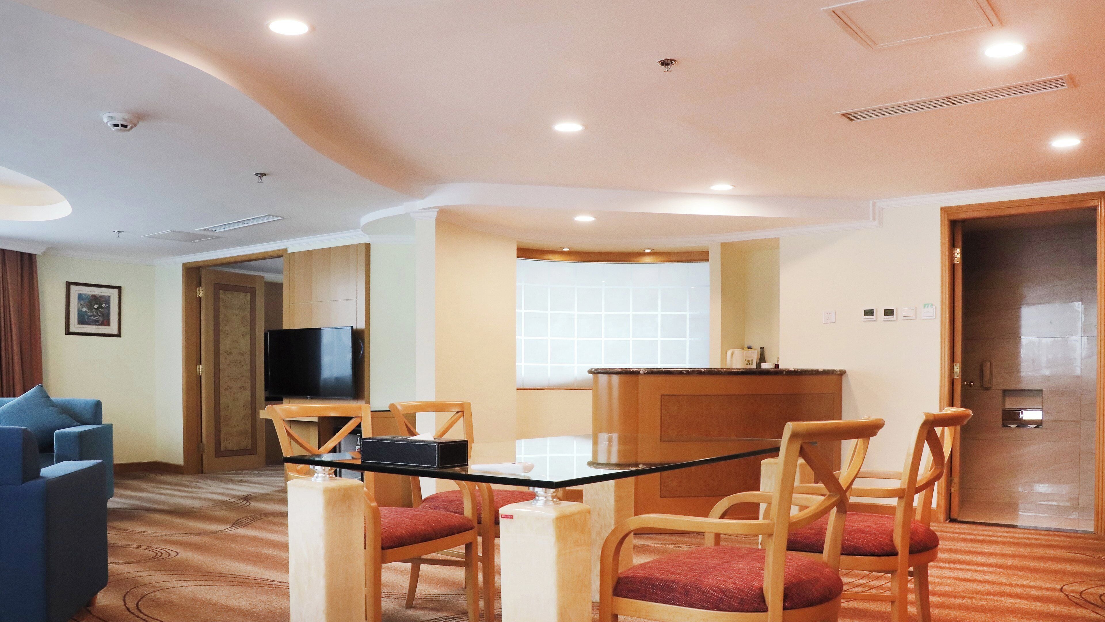 Ein Hotelzimmer mit Essbereich, Fernseher und Badezimmer.