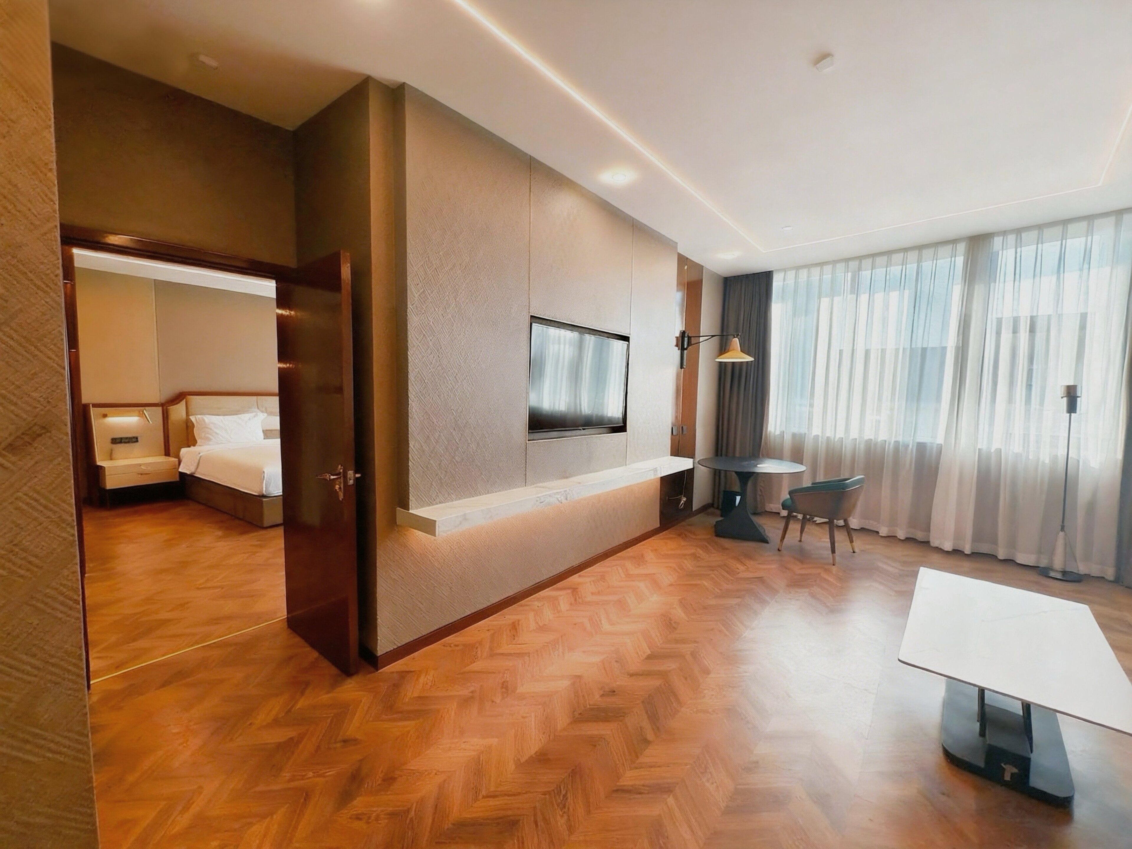 A hotel room with a bed, a TV, a desk, and a chair.
