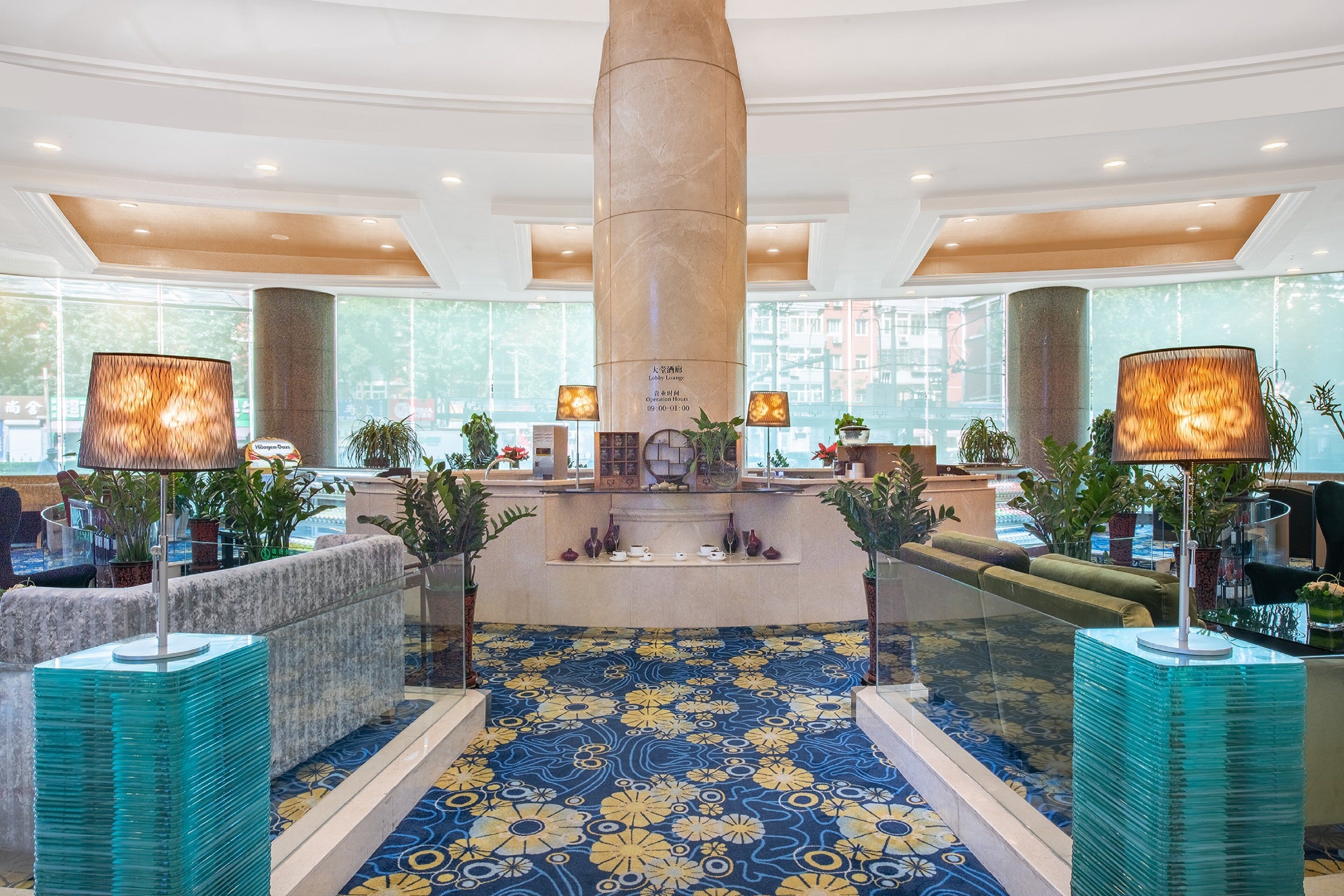 A lobby with a central column, seating areas, and a patterned floor.
