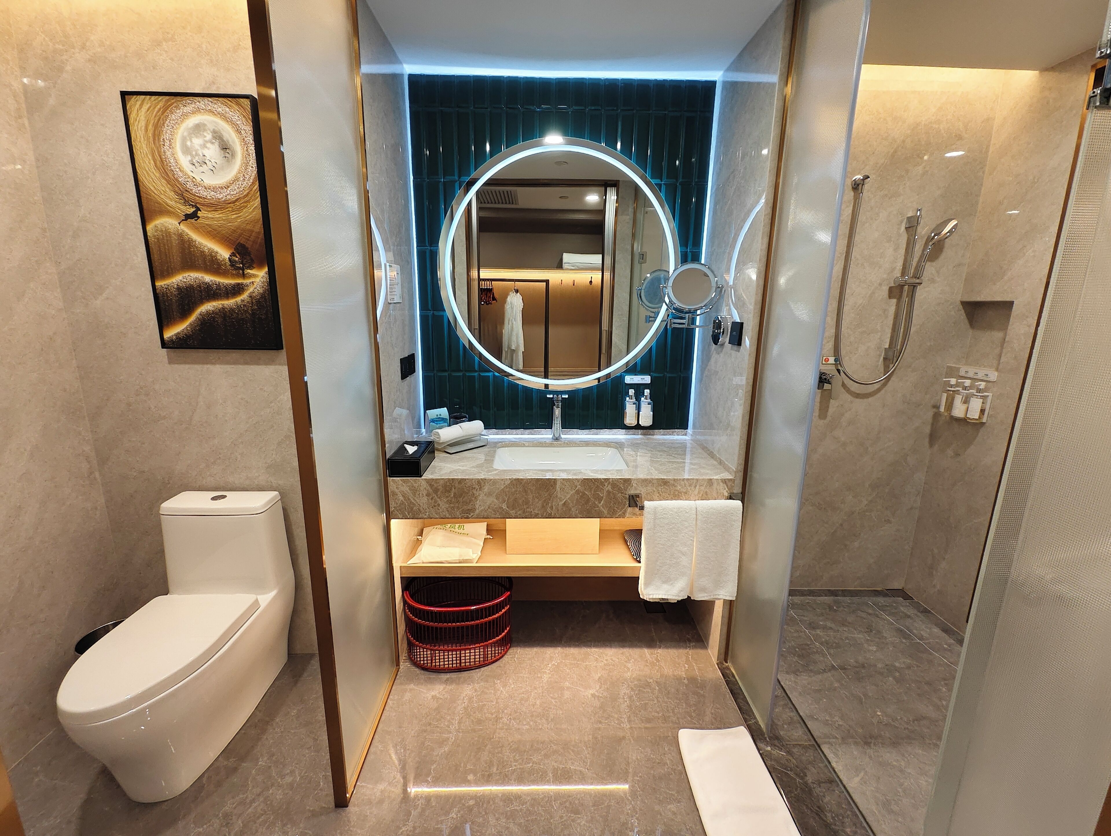 Un baño moderno con inodoro, lavabo, espejo y ducha.