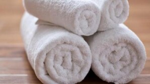 Tres toallas blancas enrolladas apiladas unas sobre otras.