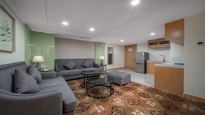 Una sala de estar moderna con un sofá gris, una mesita de centro pequeña y un piso estampado.