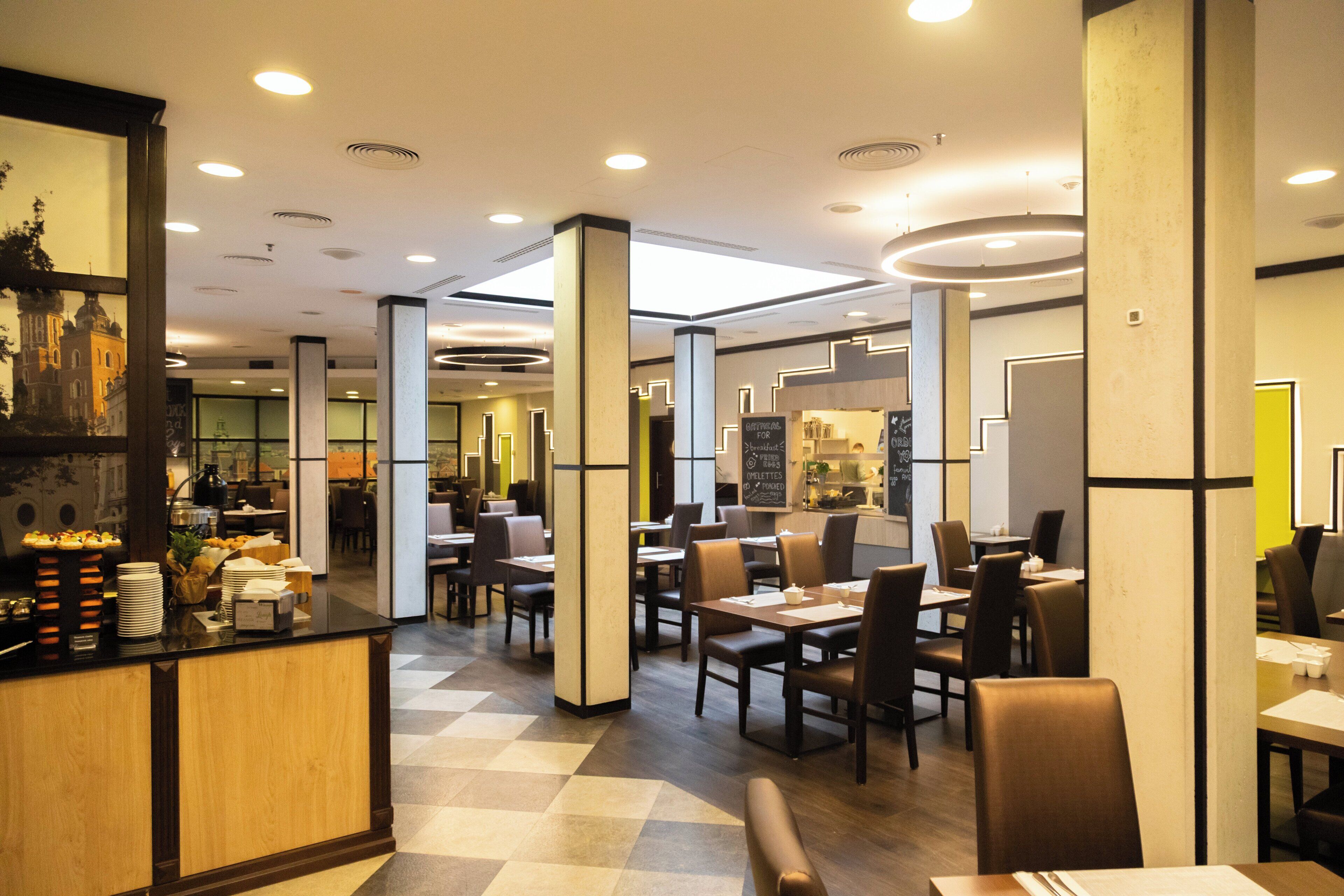 Un restaurante moderno con suelo a cuadros, mostrador de madera y varias mesas y sillas.