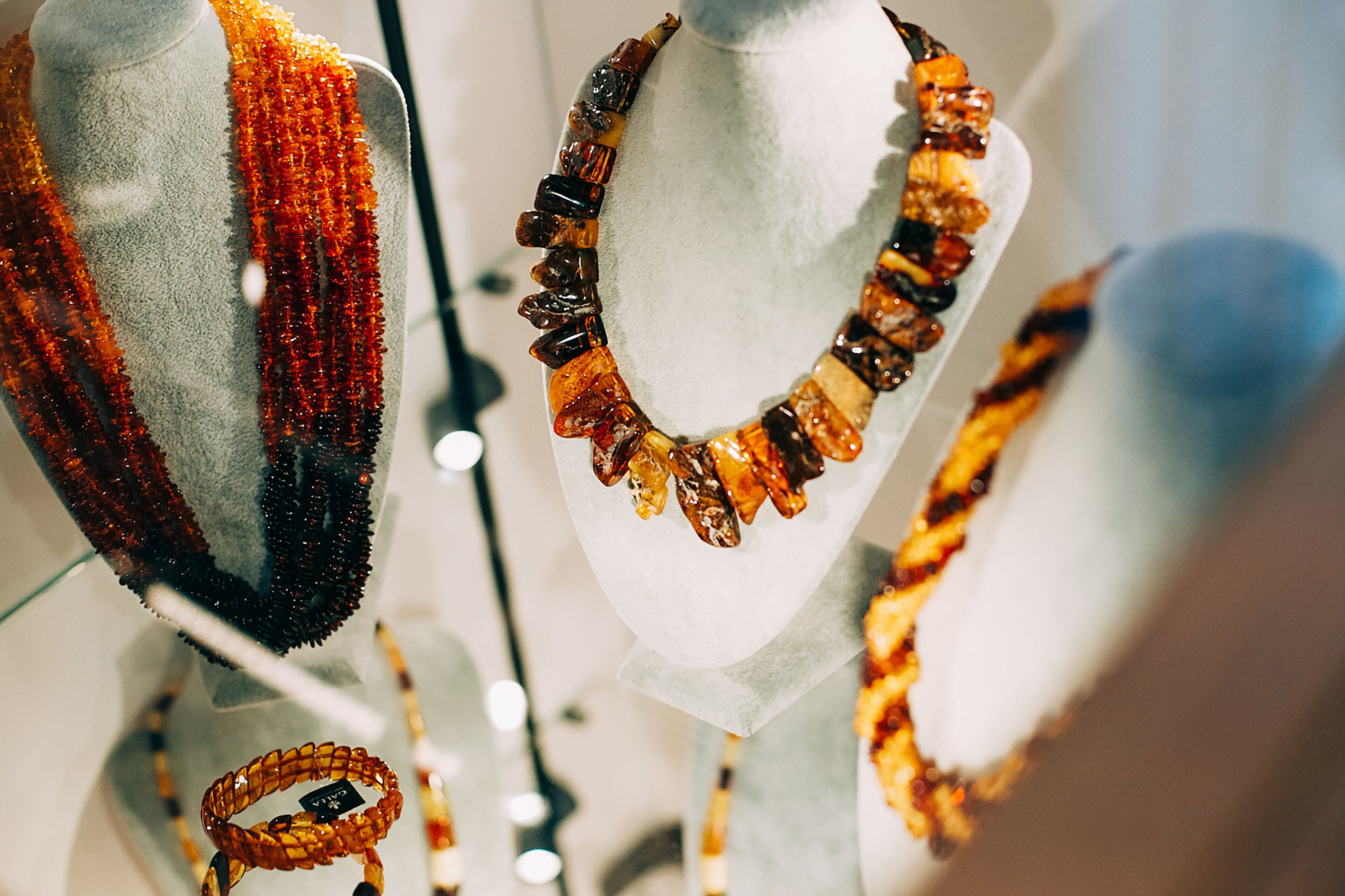 A display of necklaces on white mannequins.