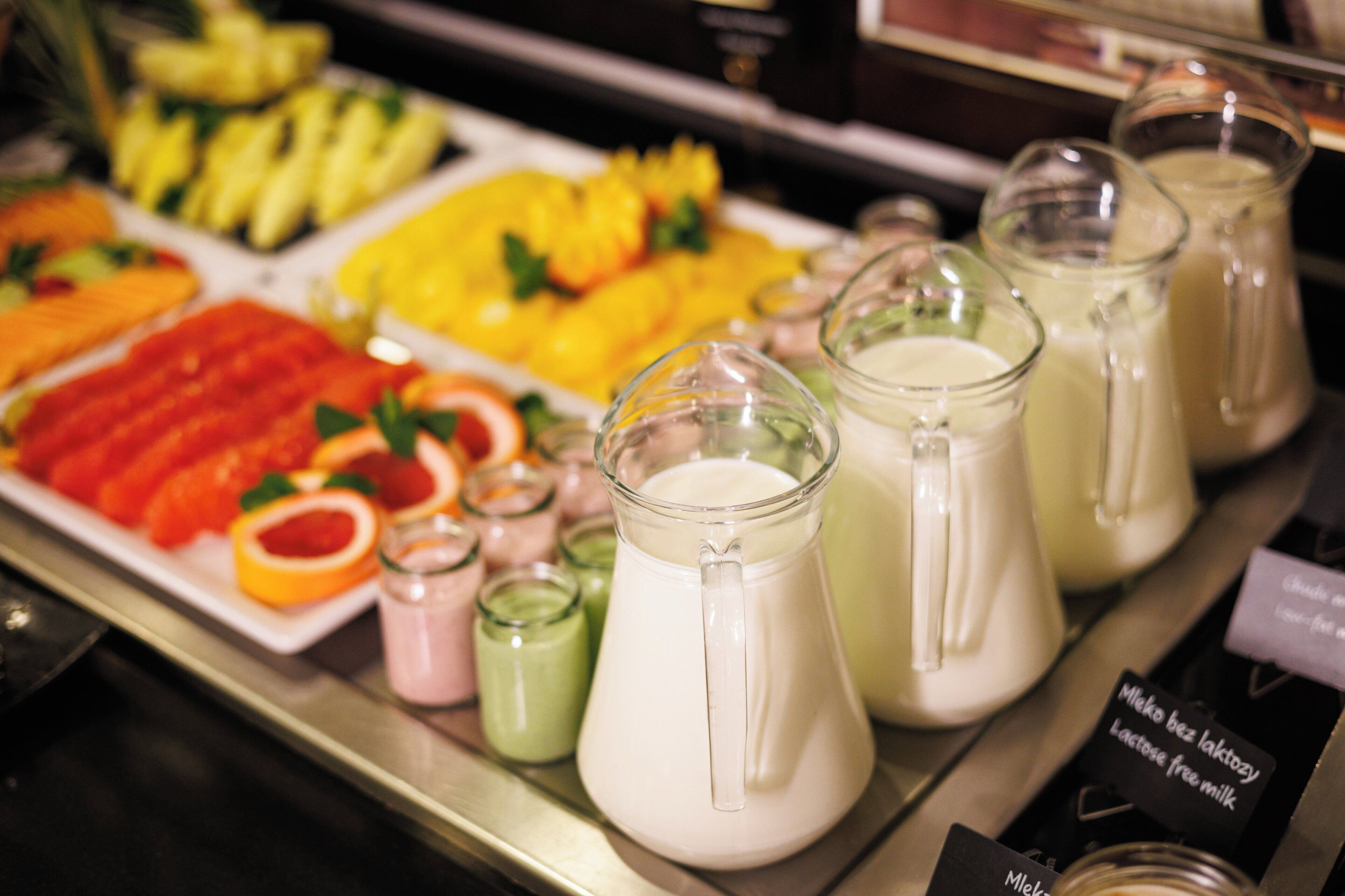 Una estación de bebidas con diversas opciones y una bandeja de frutas.