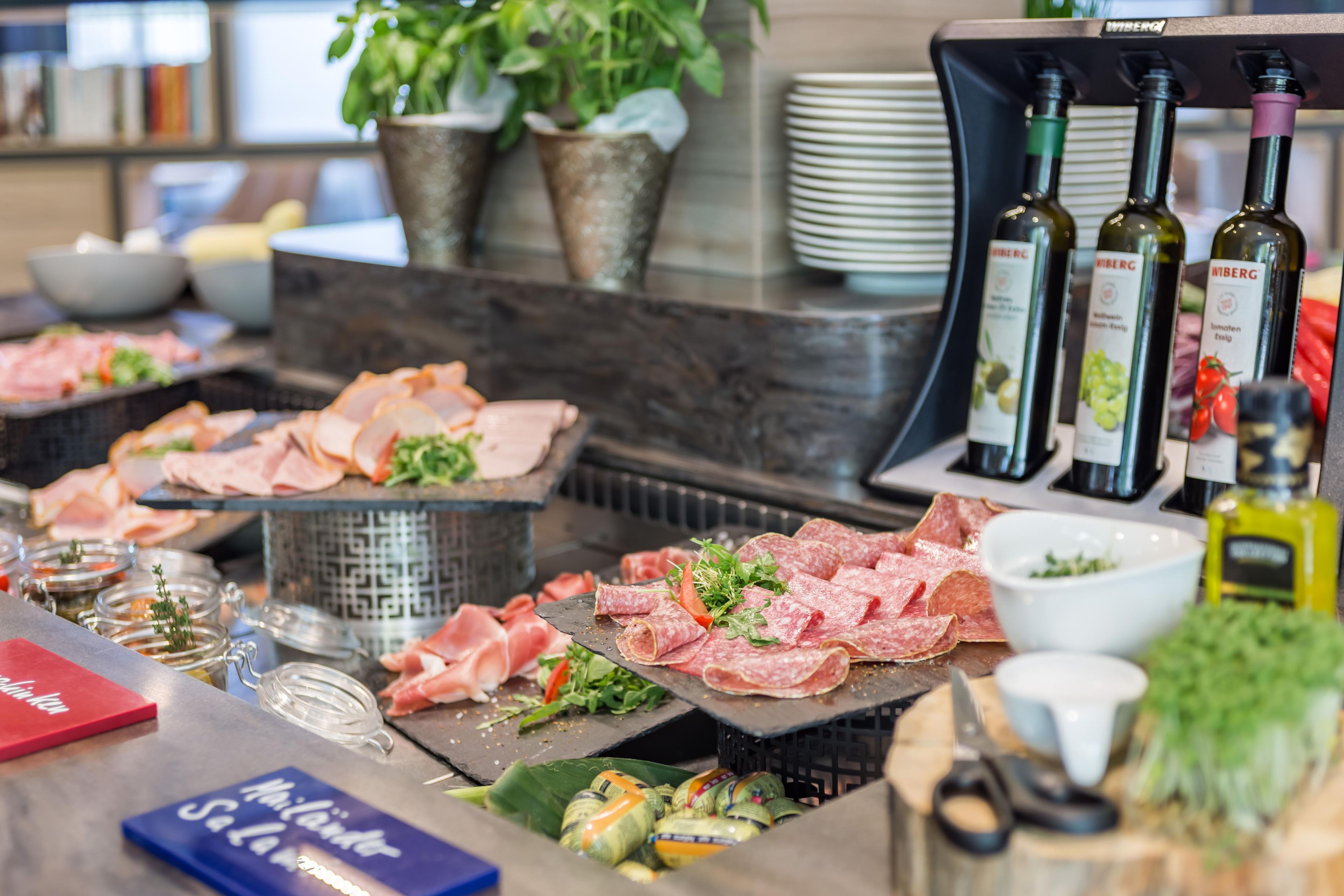 A buffet with various meats, cheese, and condiments.