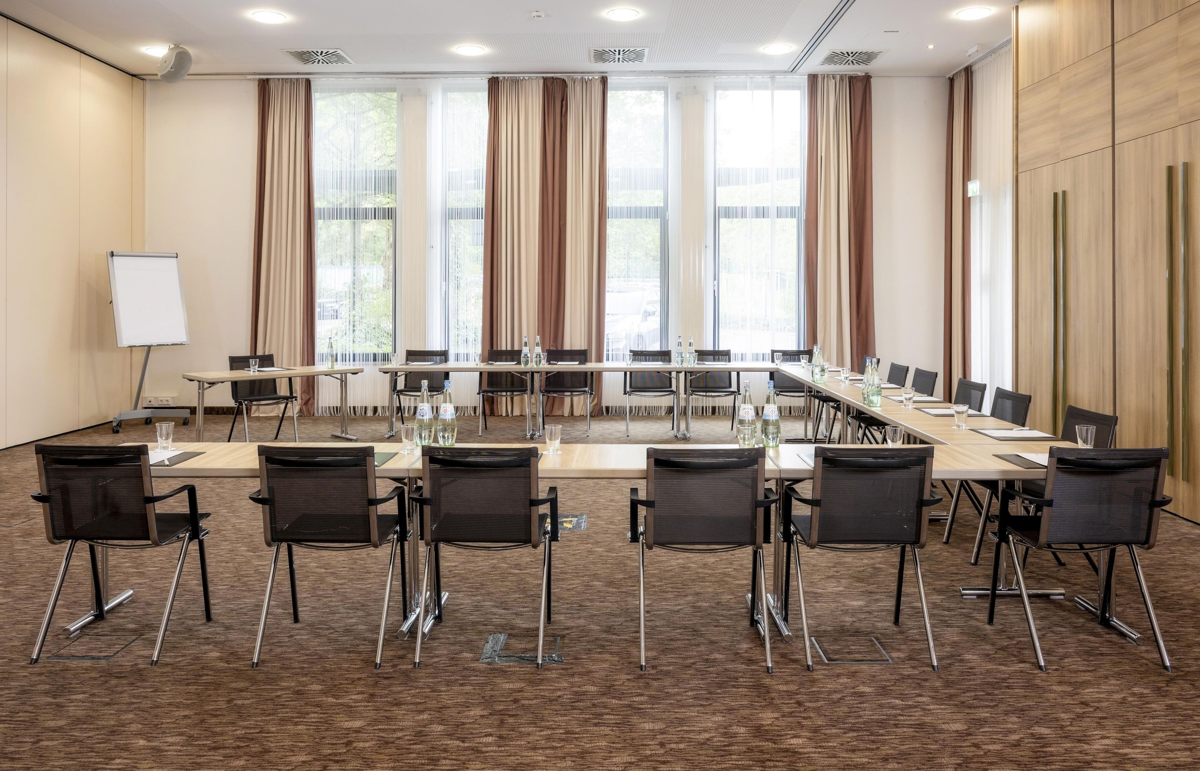 Una sala de conferencias con una larga mesa, sillas y una pizarra.