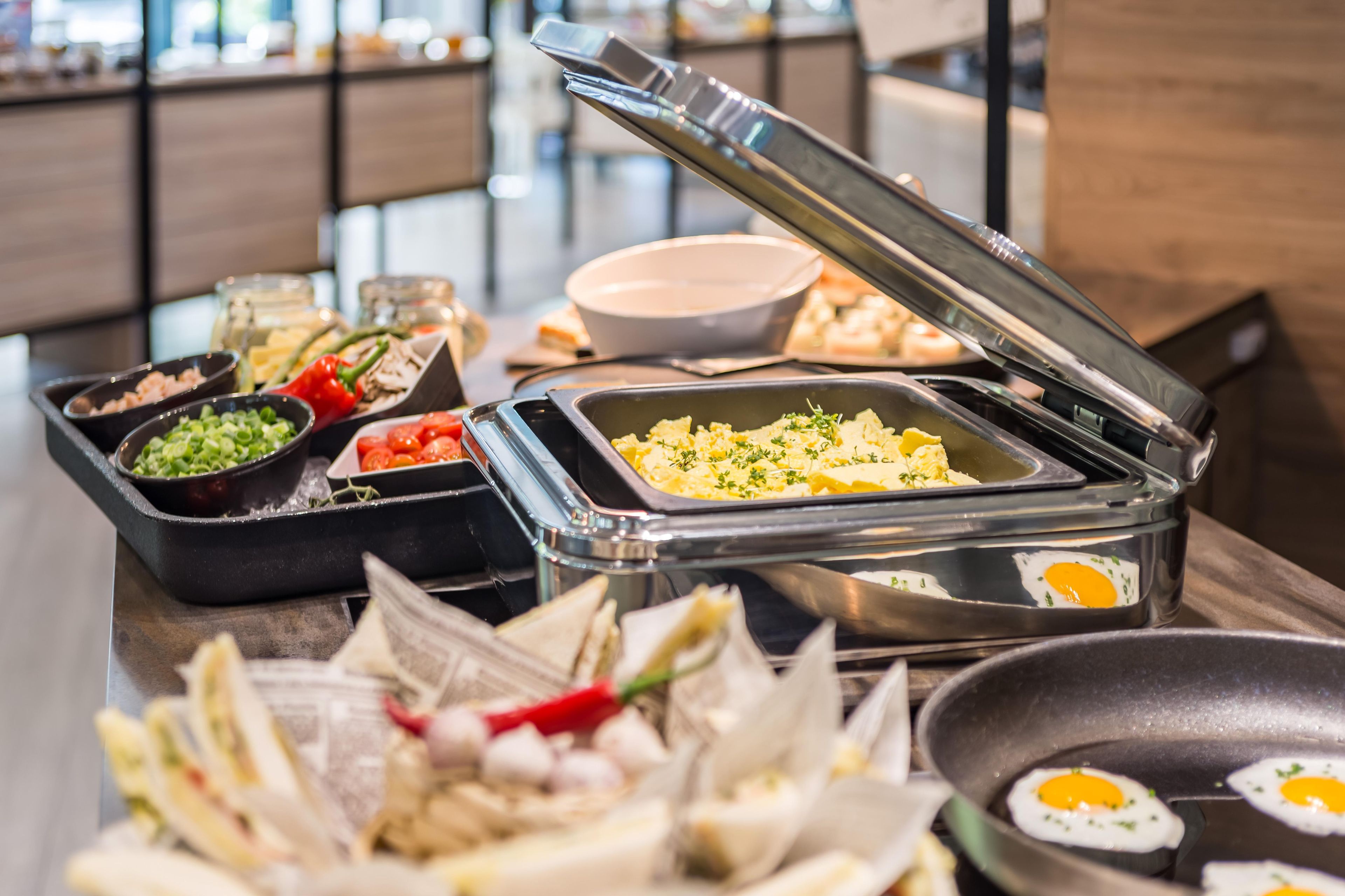 A buffet with various food items including eggs, vegetables, and rice.