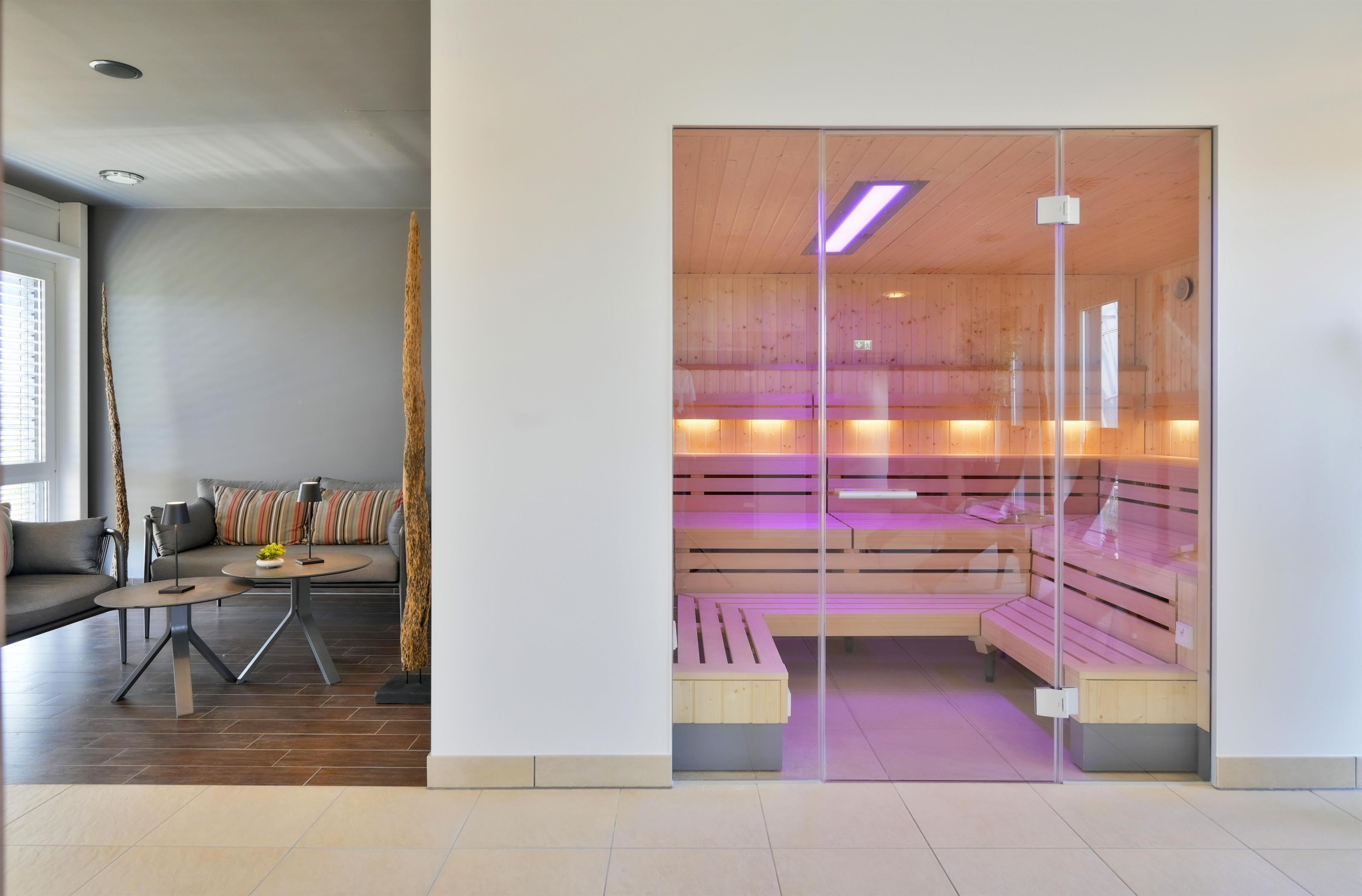 A modern interior with a seating area, a sofa, a coffee table, and a glass partition.