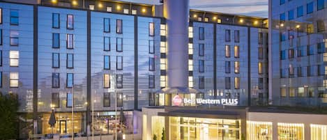 A modern hotel with a prominent '15' tower, a 'Best Western PLUS' sign, and a bar area.