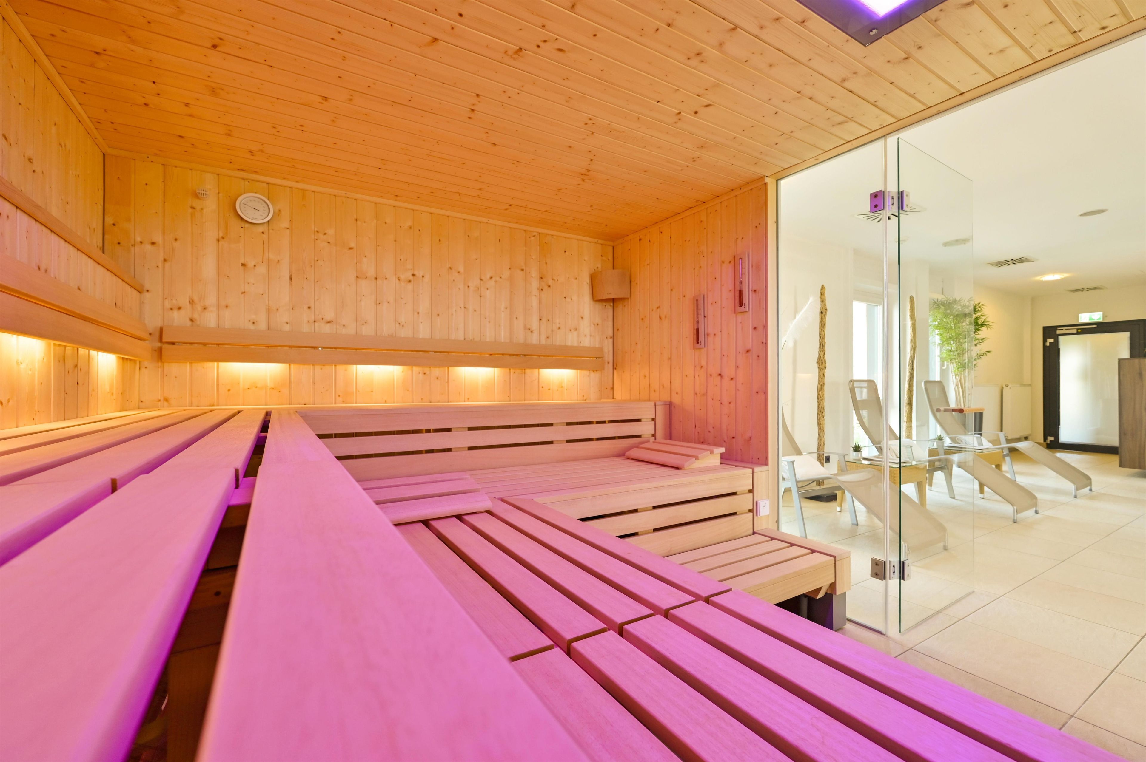 A sauna room with wooden benches and a glass wall.